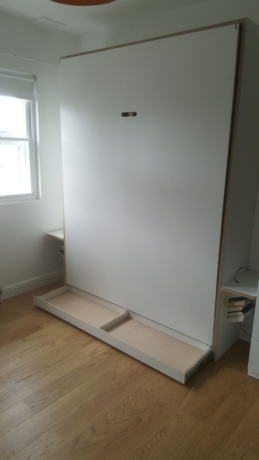 The bed folded up with the drawer pulled out underneath