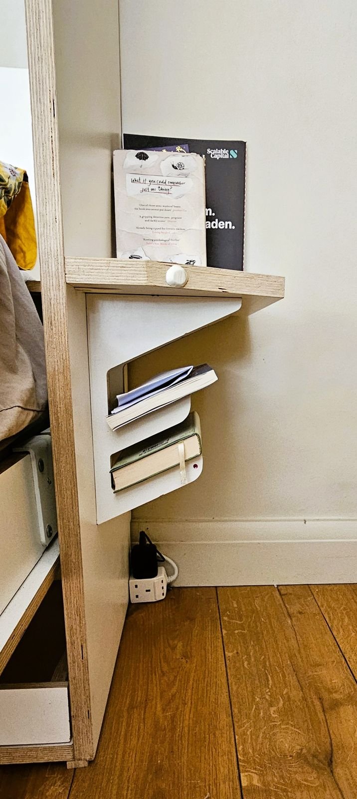 Bedside shelf on the outside of the unit holding books