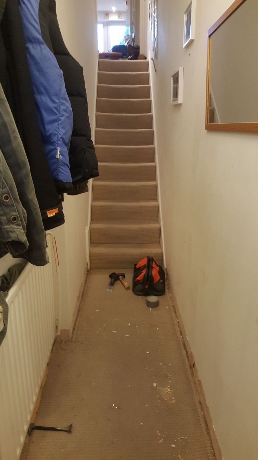 The long narrow hallway before, with bare stairs