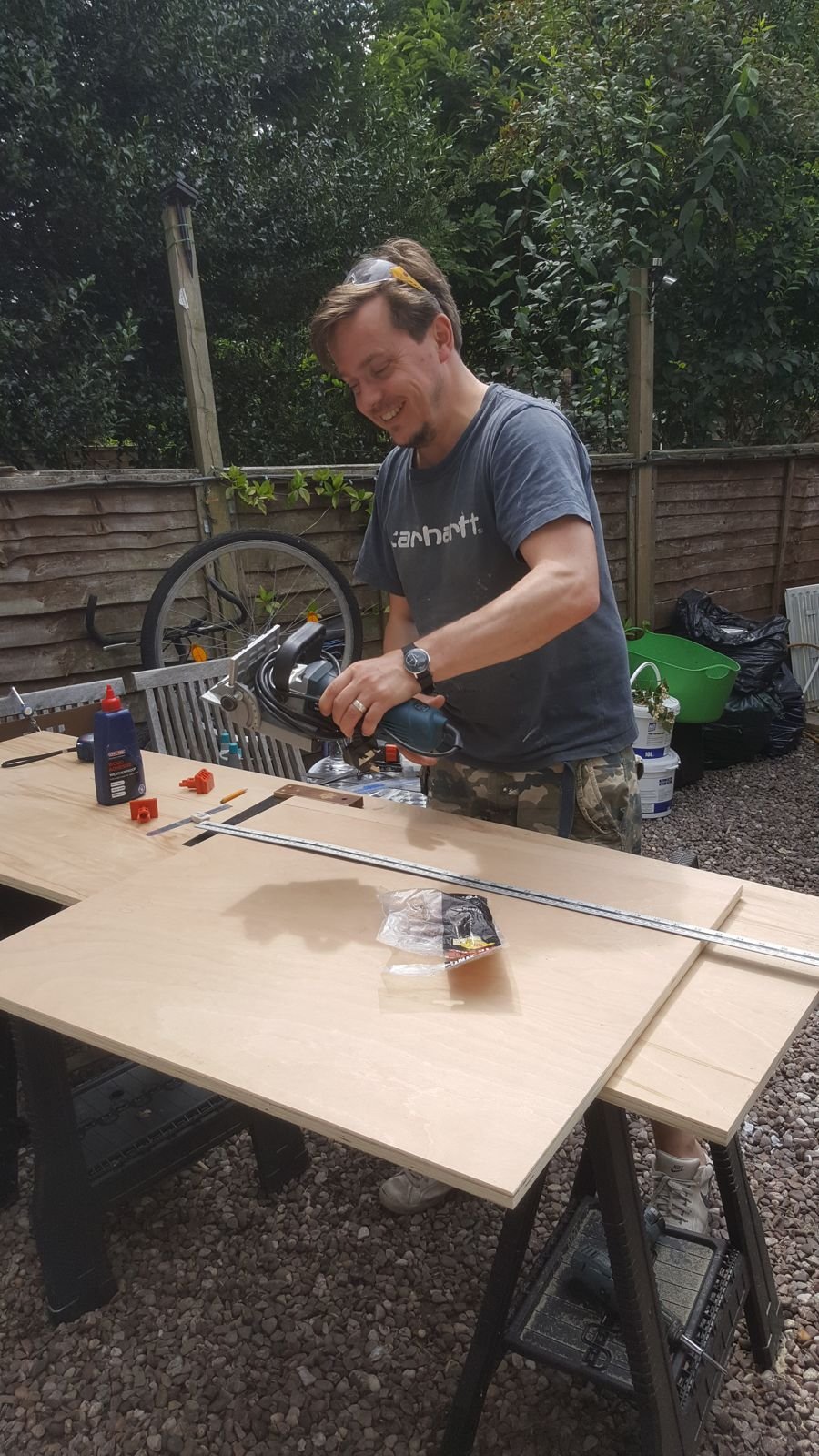 Simon cutting plywood with a track saw in the garden