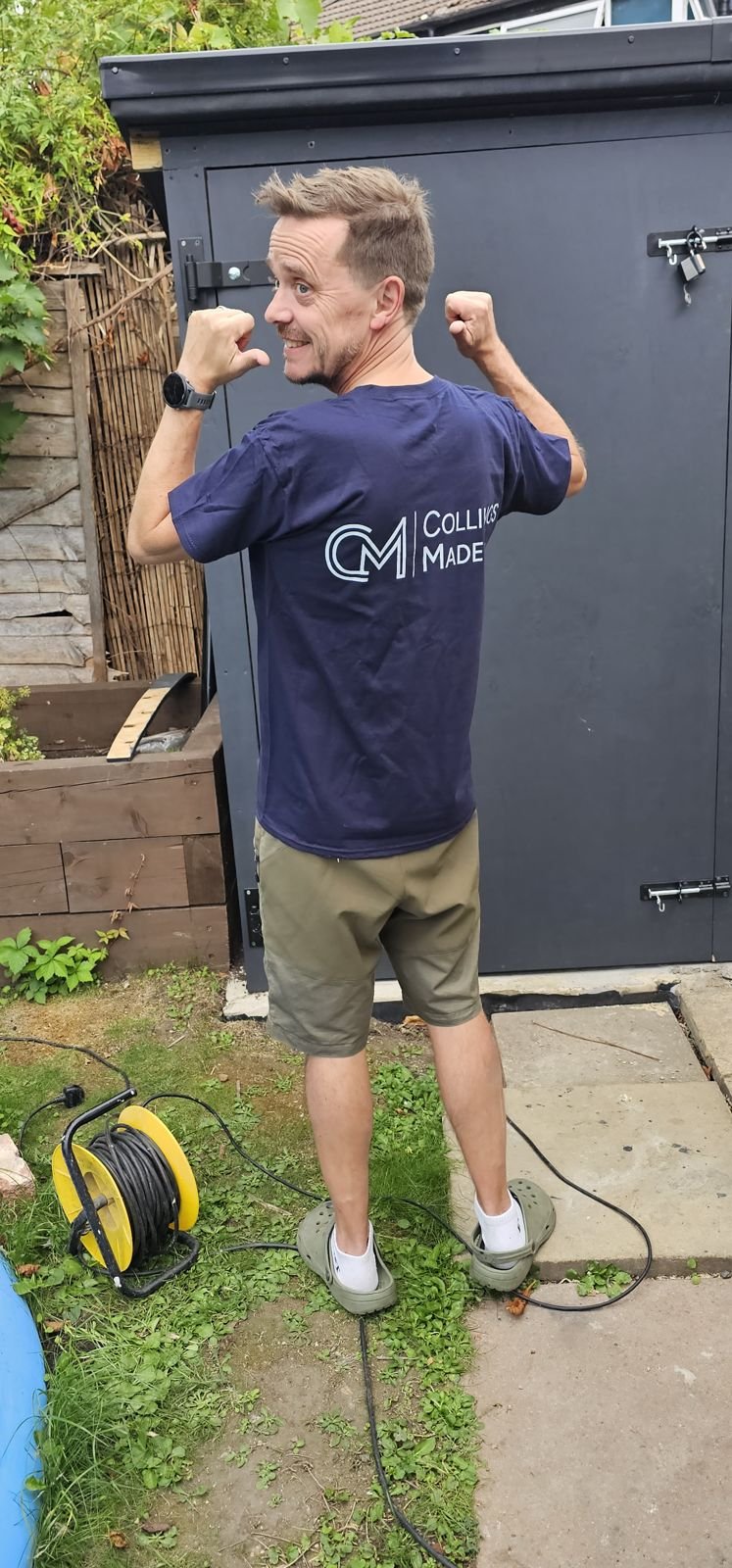 Simon Collings in a Collings Made t-shirt outside his workshop shed
